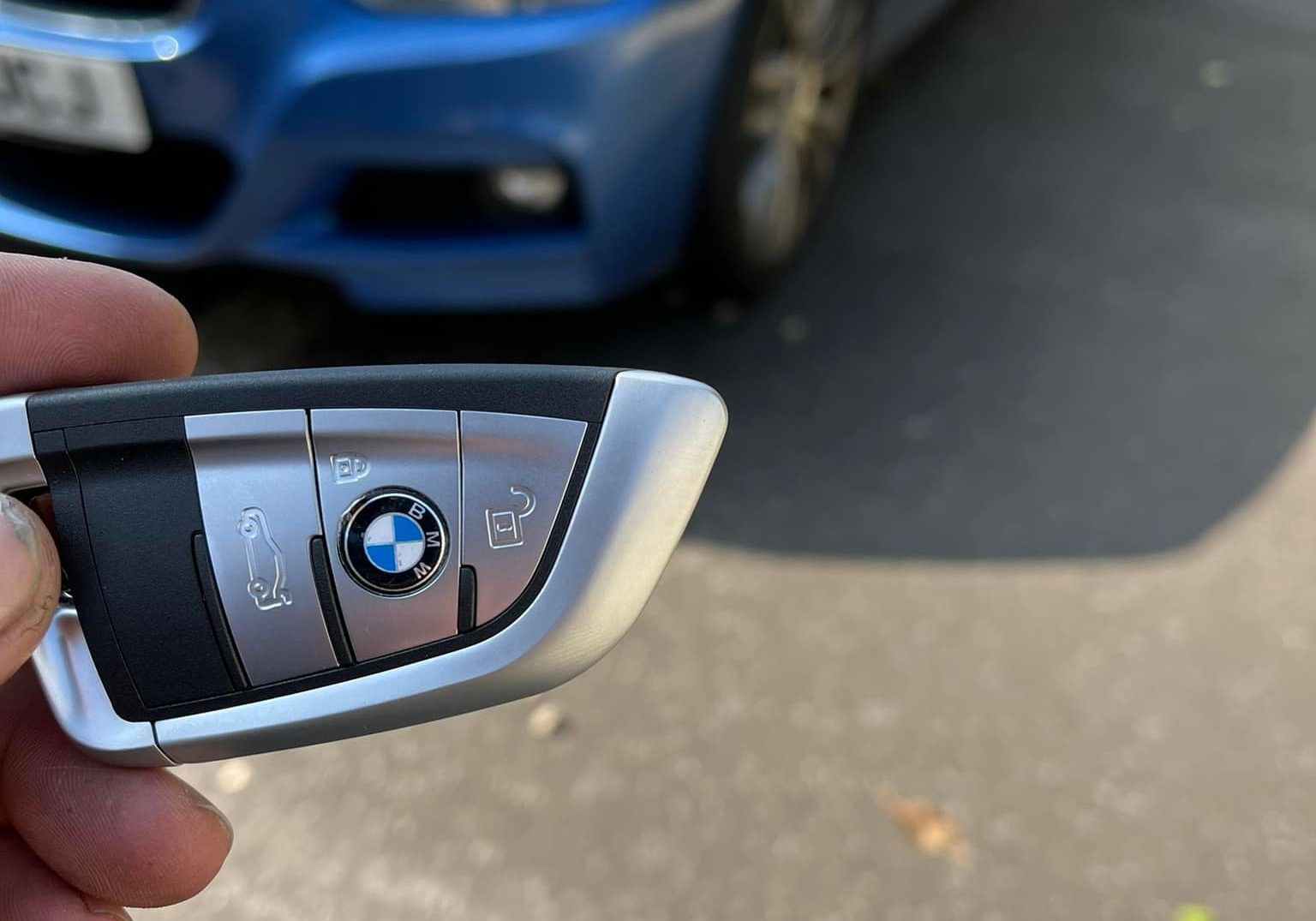 Upgraded BMW car key with blue BMW in the background